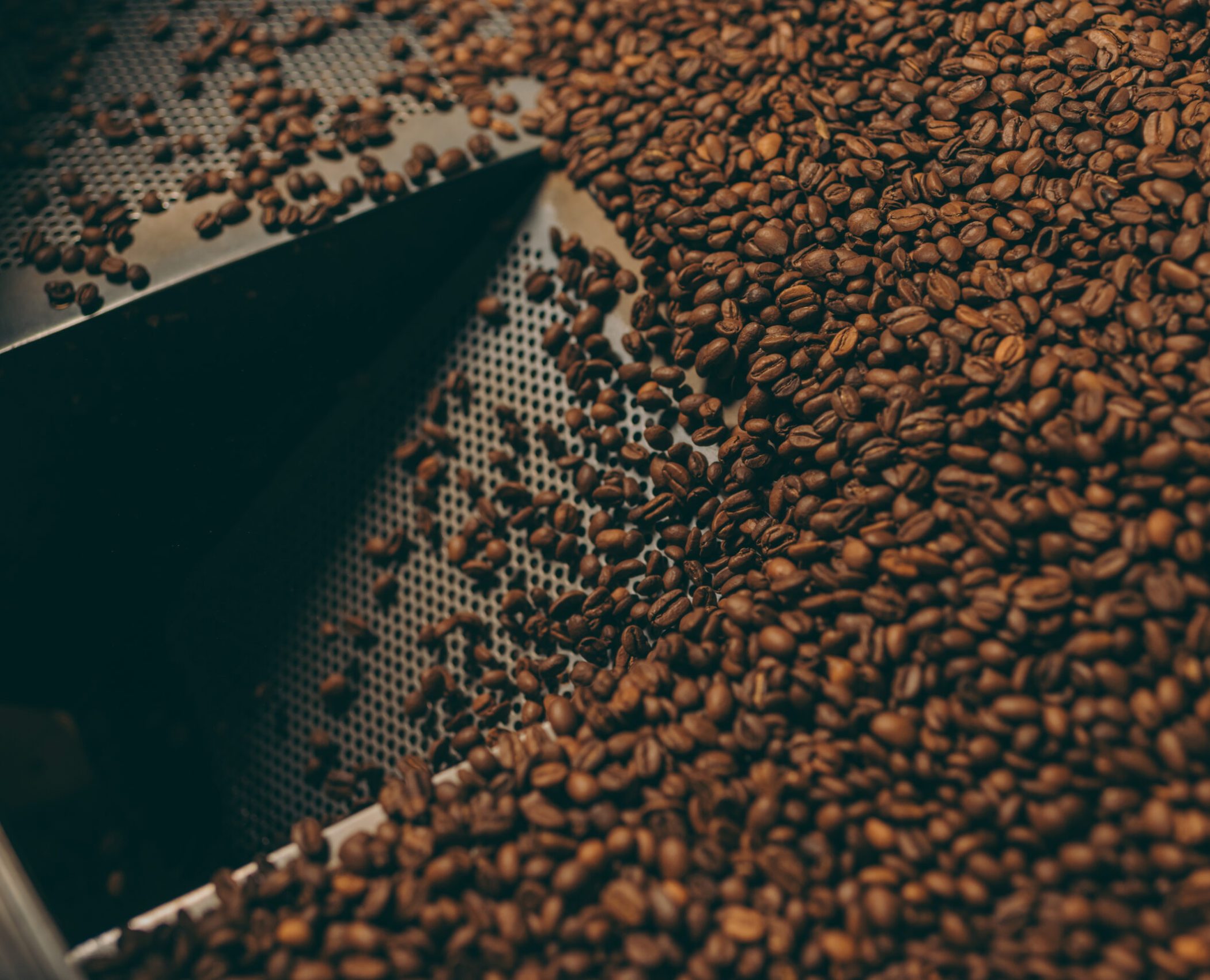 close up view of coffee beans roasting in machine